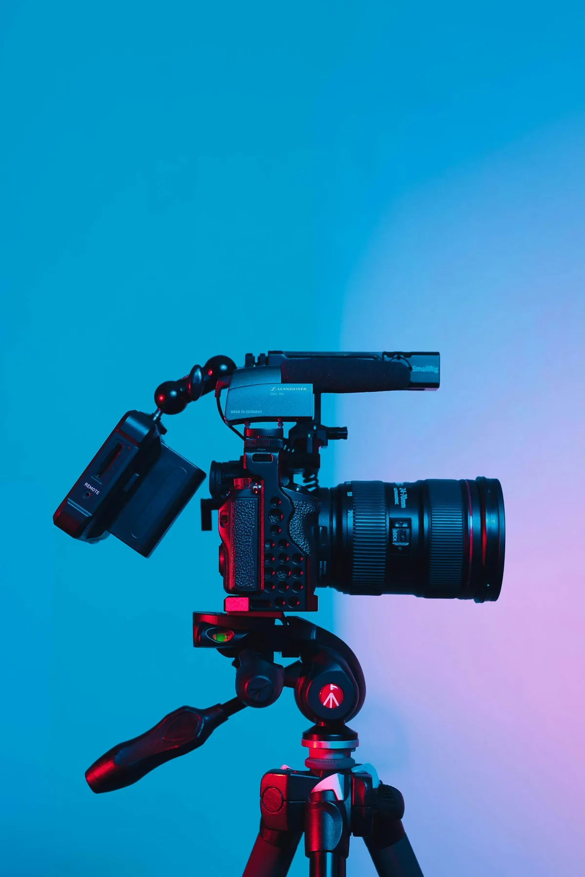 Videokamera s mikrofonem a monitorem připravená na stativu